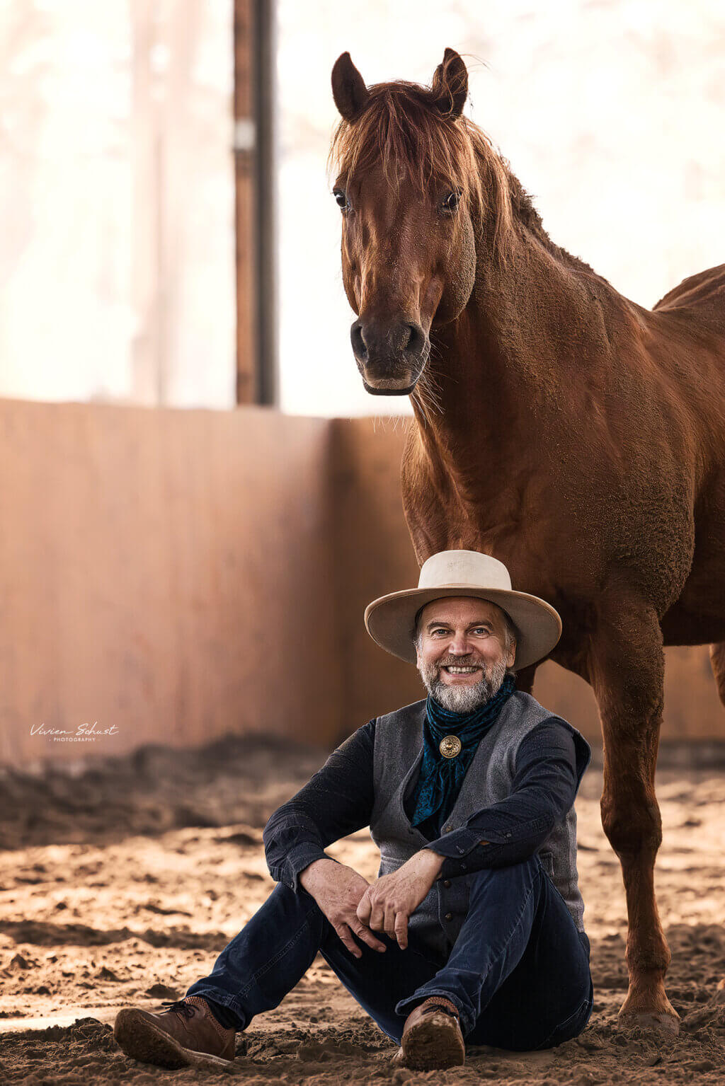 Ernst-Peter Frey sitzend vor einem Pferd in der Reithalle